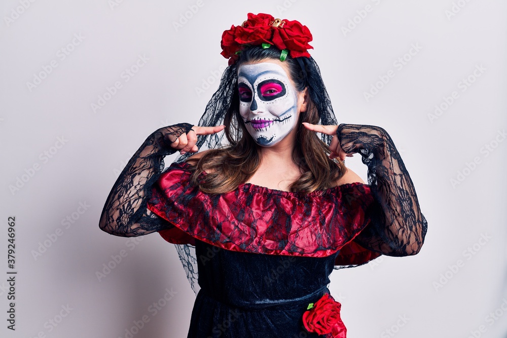 Young woman wearing day of the dead costume over white smiling cheerful showing and pointing with fingers teeth and mouth. dental health concept.