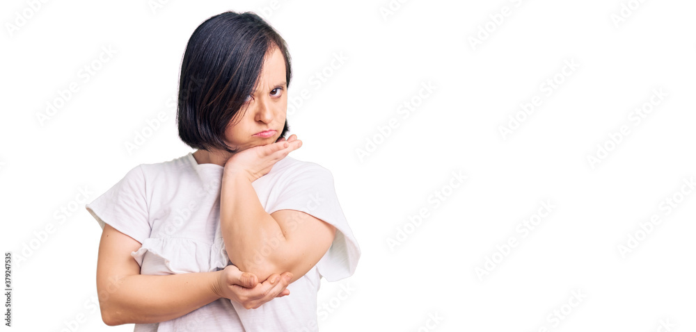 Brunette woman with down syndrome wearing casual white tshirt thinking looking tired and bored with depression problems with crossed arms. Brunette woman with down syndrome wearing casual white tshirt thinking looking tired and bored with depression problems with crossed arms.