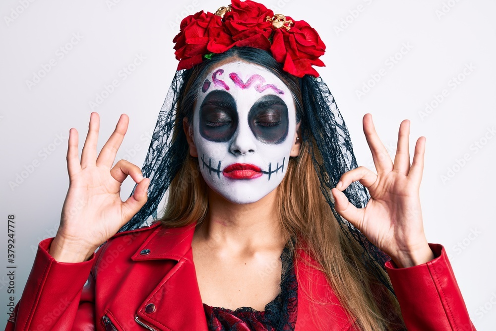 Woman wearing day of the dead costume over white relax and smiling with eyes closed doing meditation gesture with fingers. yoga concept.