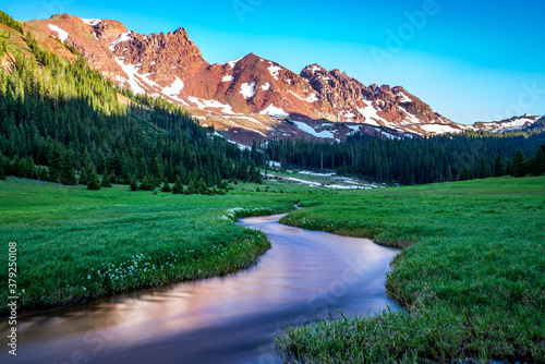 Stream through meadow surrounded by mountains, Snowmass Wilderness photo