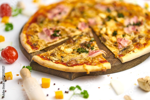 Delicious pizza with sausage, mushrooms, bacon on wooden plate