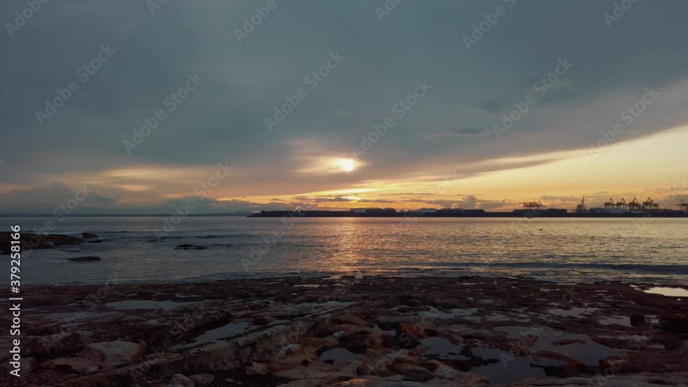 Sun hiding behind clouds in bay of Sydney with large cranes in distance, slowmo Sun hiding behind clouds in bay of Sydney with large cranes in distance, slowmo
