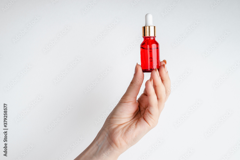 Young woman holding in hands Essence for facial health with pomegranate extract. Antiage cosmetics for skin lifting. Serum in red glass bottle against. Organic Vegan Product. Place for text
Young woman holding in hands Essence for facial health with pomegranate extract. Antiage cosmetics for skin lifting. Serum in red glass bottle against. Organic Vegan Product. Place for text