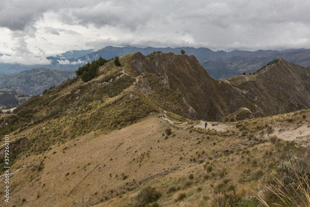 mountain with dry vegetation, cloudy sky and dirt road with dust mountain with dry vegetation, cloudy sky and dirt road with dust
