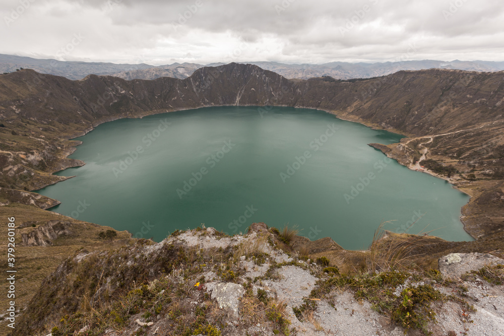 lake in the crater of an active volcano in Ecuador, Quilotoa. Cloudy sky with high mountains