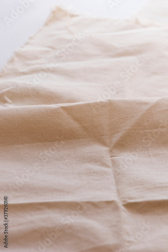 Fondo de tela Tela tipo lino de color beige con arruga. Tela de algodón natural Ropa artesanal. Tela ecológica plegada con textura y sombras.