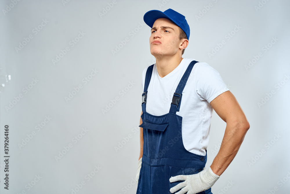 Man worker in forklift uniform delivery service light background Man worker in forklift uniform delivery service light background