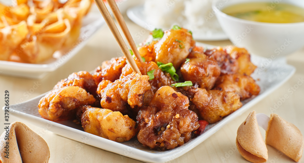 using chopsticks to eat chinese general tsos chicken meal with crab rangoon and egg drop soup using chopsticks to eat chinese general tsos chicken meal with crab rangoon and egg drop soup