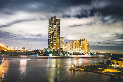 Fantastic night time skyline with high rise apartment building by the Chao Praya river in Bangkok  Thailand.