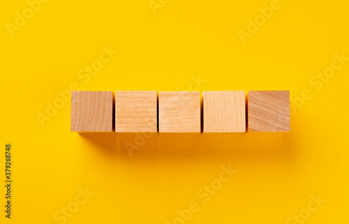 Fototapeta Naklejka Na Ścianę i Meble -  Top view of wooden cubes on yellow