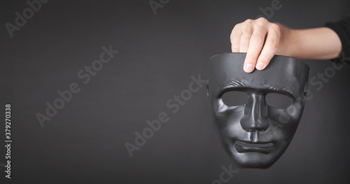 Bild auf Leinwand Man holding black mask. Fake, anonymous