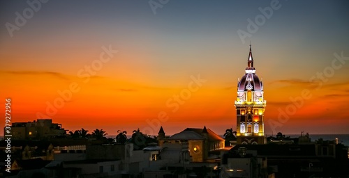 Wonderful panoramic view after sunset over Cartagena with illuminated Cartagena Cathedral against orange-yellow sky 