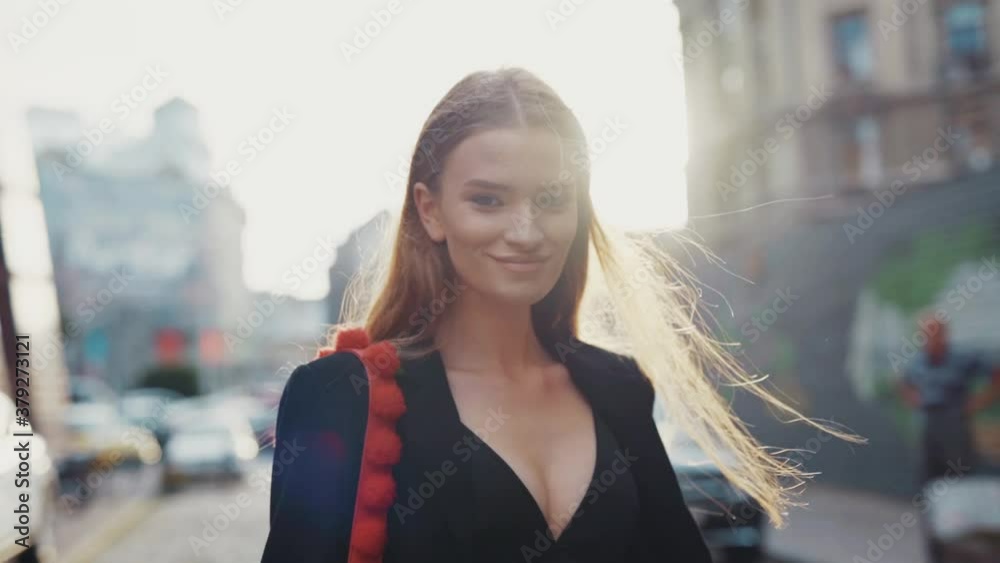 Shot back gorgeous young woman walking turns to camera smiling at sunlight on street city pretty lady fashion model natural sexy close up slow motion