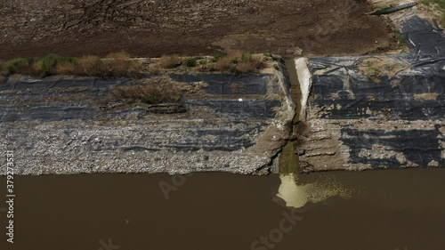 Aerial shot of a manure lagoon over flow spout draining into the next cell. Farming. Waste. photo