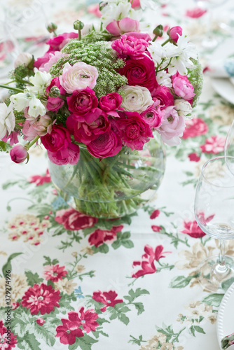 Pretty spring flower bouquet on a glass vase on colorful tablecloth