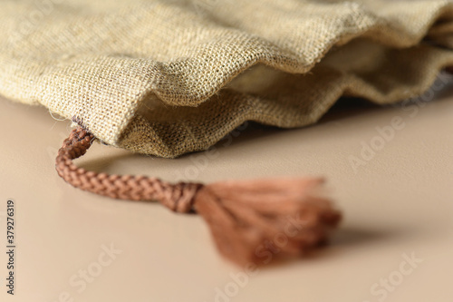 A small burlap canvas bag with rope ties. Rustic style for a gift.