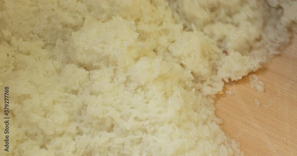 Sushi Rice Preparation - Freshly Cooked Japanese Rice Mixed By The Sushi Chef Using A Wooden Spoon. - high angle shot Sushi Rice Preparation - Freshly Cooked Japanese Rice Mixed By The Sushi Chef Using A Wooden Spoon. - high angle shot