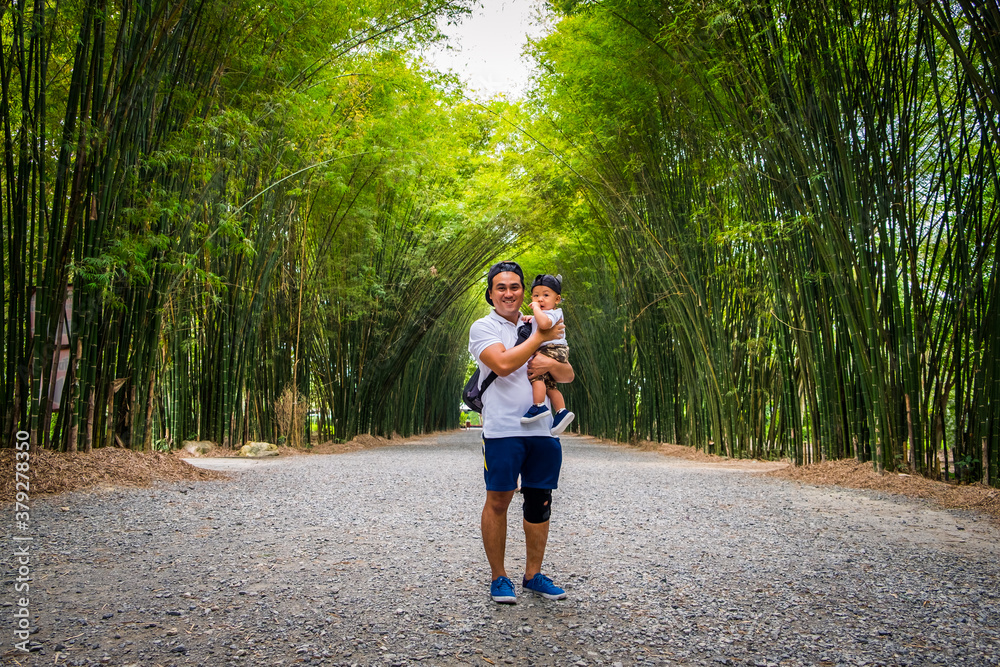 Father and son having good time outdoors at bamboo forest at Thailand. Concept of friendly family and summer vacation. Father and son having good time outdoors at bamboo forest at Thailand. Concept of friendly family and summer vacation.
