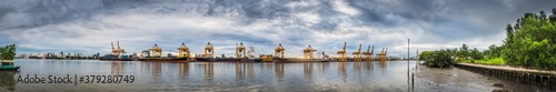 Panorama photo of harbor with anchored ship. Container cargo freight ship with working crane bridge at shipyard in for logistic transportation import and export at Asia haven port background, Thailand