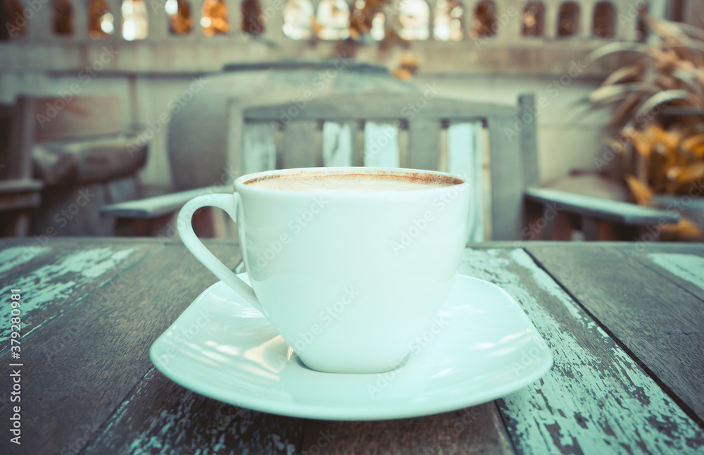Fototapeta premium Front view of hot coffee cup on wooden table at the cafe background.