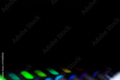 black background with defocused set of bright multicolored colorful felt-tip pens for drawing in the bottom