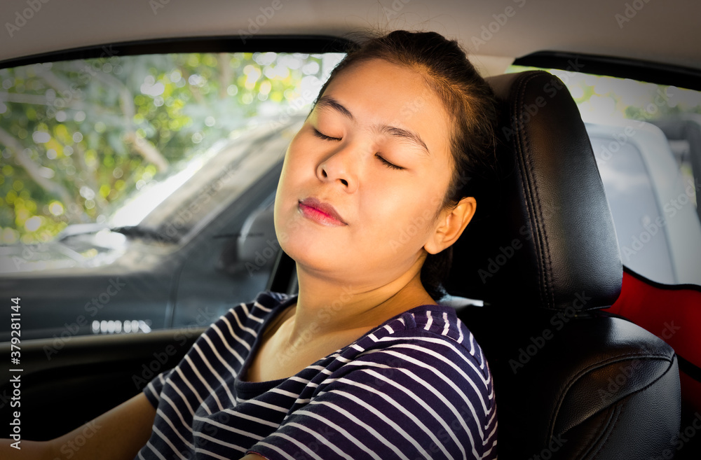 Tired Asian woman sleeping on steering wheel in her car. Businesswoman driving automobile on the road trip. Owner and dealership concept Tired Asian woman sleeping on steering wheel in her car. Businesswoman driving automobile on the road trip. Owner and dealership concept