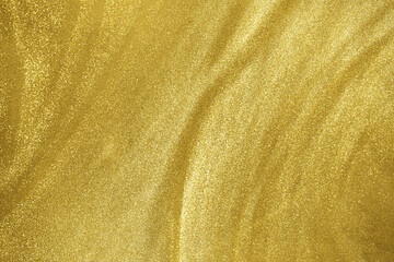 de-focused. Abstract elegant, gold glitter particles flow with shallow depth of field underwater. Holiday magic shimmering luxury background. Festive sparkles and lights.