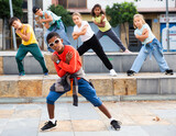 Little boy hip hop dancer exercising with friends at open air dance class