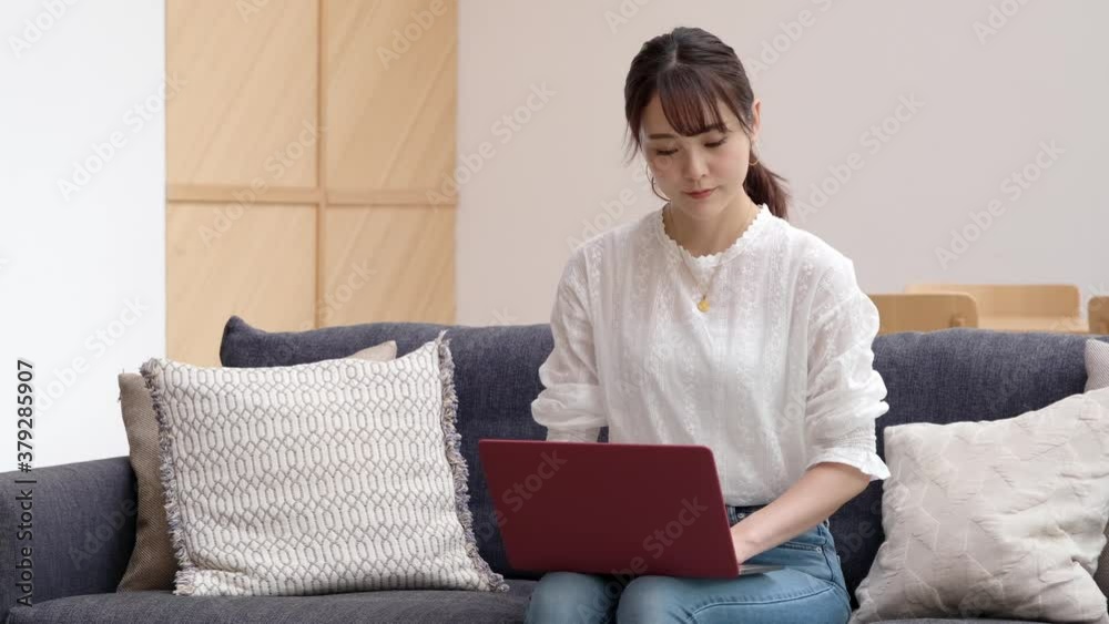 リビングでパソコンを使う女性 リビングでパソコンを使う女性