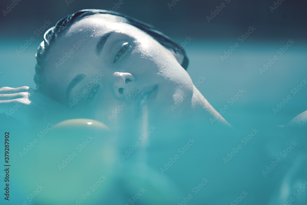 Beautiful Girl’s Face Portrait. Woman Floating In Pool At SPA And Looking At Camera.