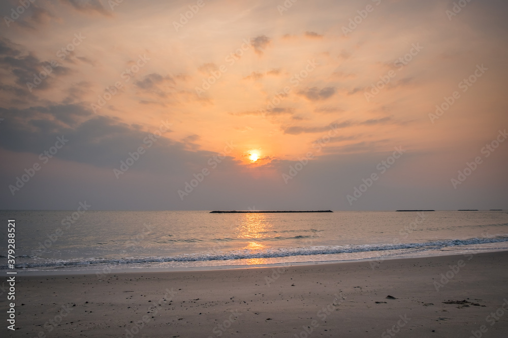Beautiful golden sunset with blue sky over the horizon on the beach, Thailand. Tropical colorful sunrise from the sea.