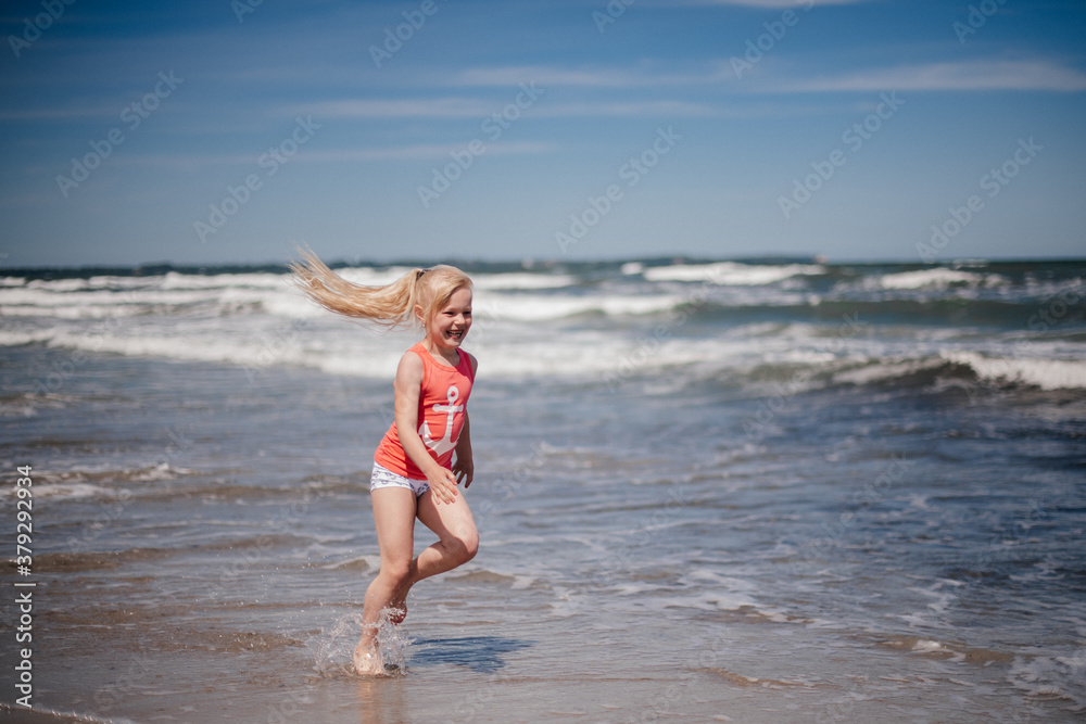 happy child running and jumping in the waves at beach. Reuniting with nature. happy child running and jumping in the waves at beach. Reuniting with nature.