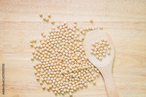Soy bean in wood spoon on wooden background. Top view