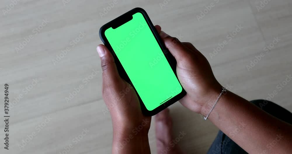 Black woman hands holding cellphone with green screen