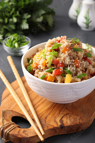 Fotografía Fried rice with vegetables, garlic, ginger and green onion on dark background