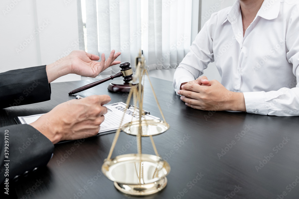 A male lawyer or a judge counseling clients about judicial justice and prosecution with scales, judges gavel, legal documents legal services concept