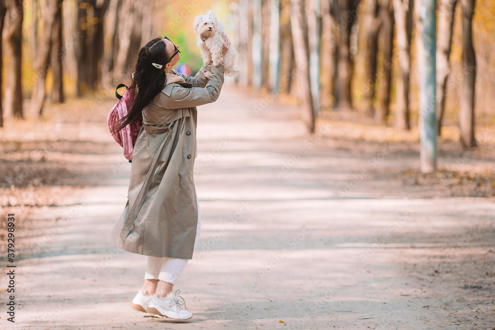 Young stylish woman walking with white dog