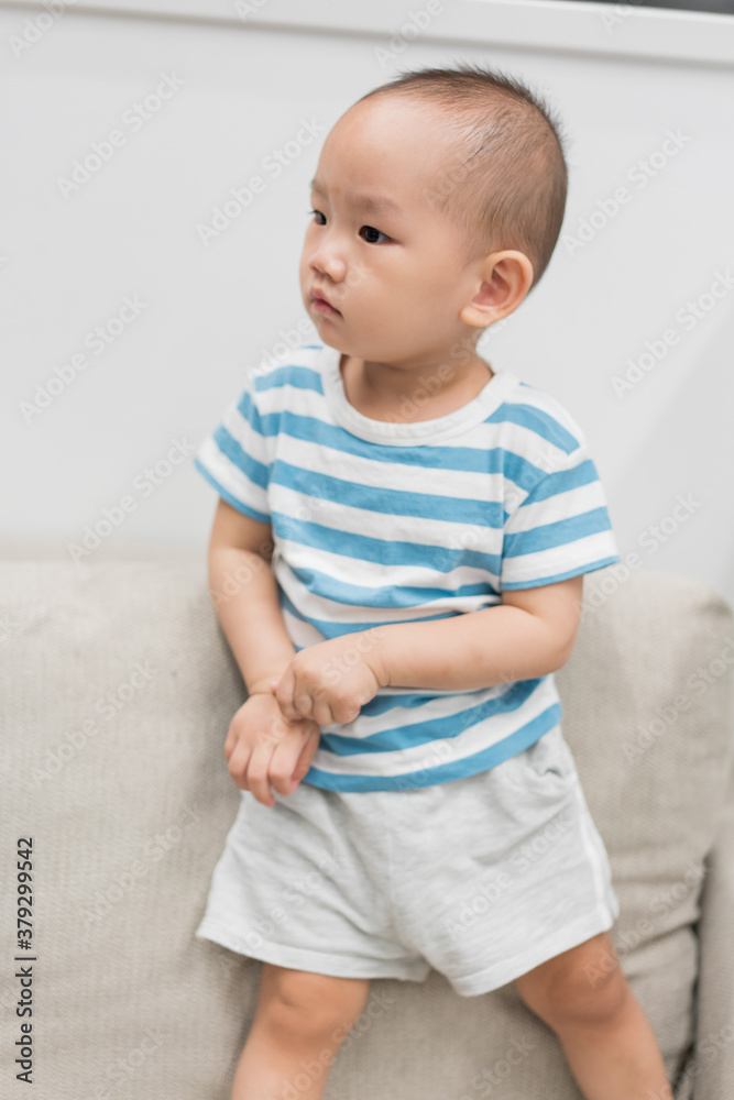Fototapeta premium A baby boy of one and a half years old is playing in the room