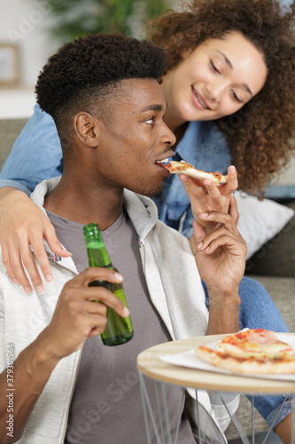 young couple eating pizza and drinking beer