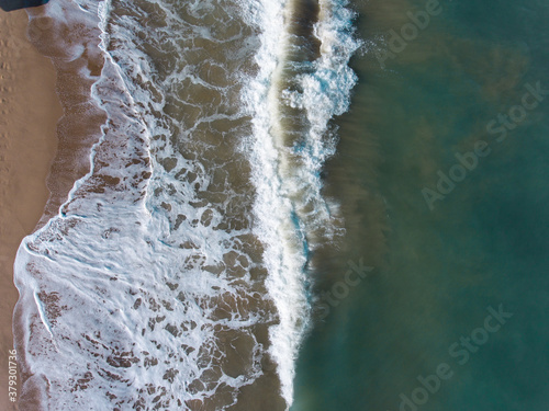 Aerial view of blue sea, waves and beach.
