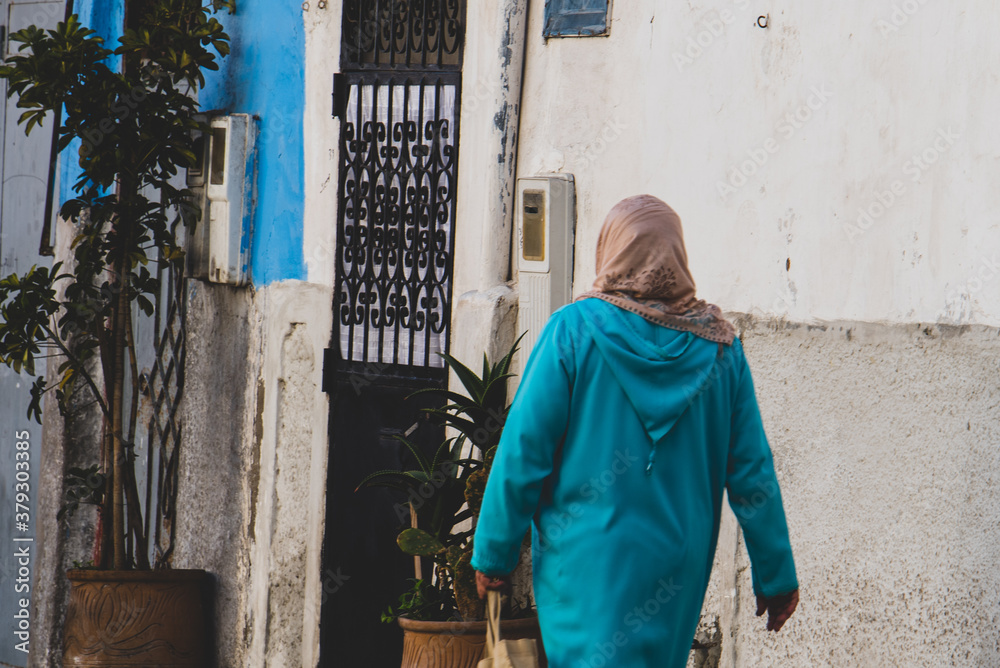 Casablanca, Morocco: 09/07/2019 : Portrait of a muslim woman with her head covered walking in the city center of Casablanca in a sunny day. Woman crossing the streets of the eastern markets