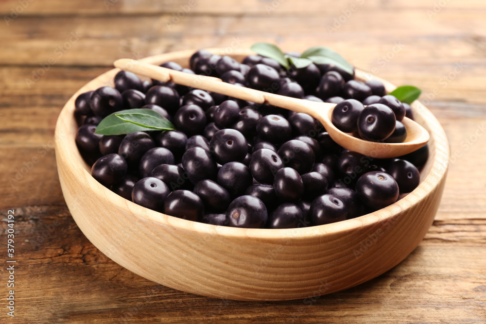 Fresh acai berries in plate on wooden table Fresh acai berries in plate on wooden table