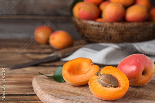Delicious fresh ripe apricots on wooden table, closeup. Space for text