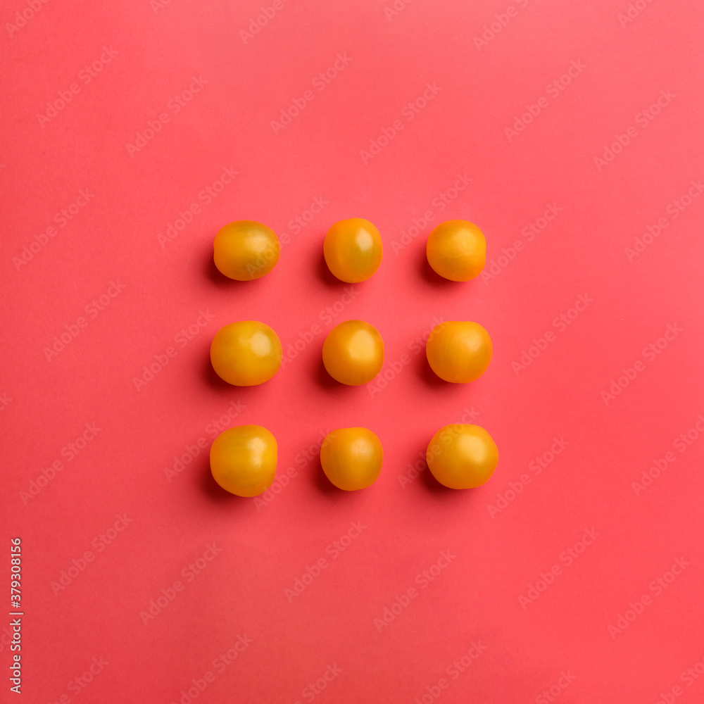 Yellow tomatoes on red background, flat lay Yellow tomatoes on red background, flat lay