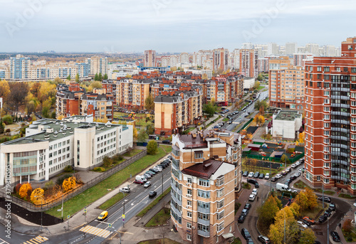 Aerial view of modern city residential neighborhood with long stretching roads in the autumn day.
