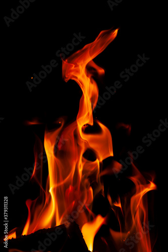 Fiery flame with sparks on a black background. Texture  element  for barbecue or cooking.