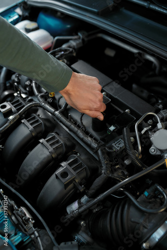 Close up of man hand checking the engine of a broken car