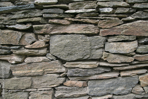 Horizontal picture of gray stone wall. Decoration with stones for background