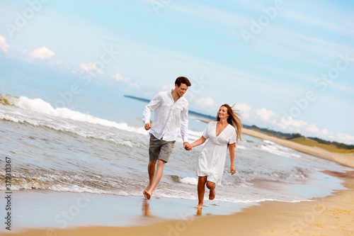 Nice couple of young people in love have fun on the sea coast