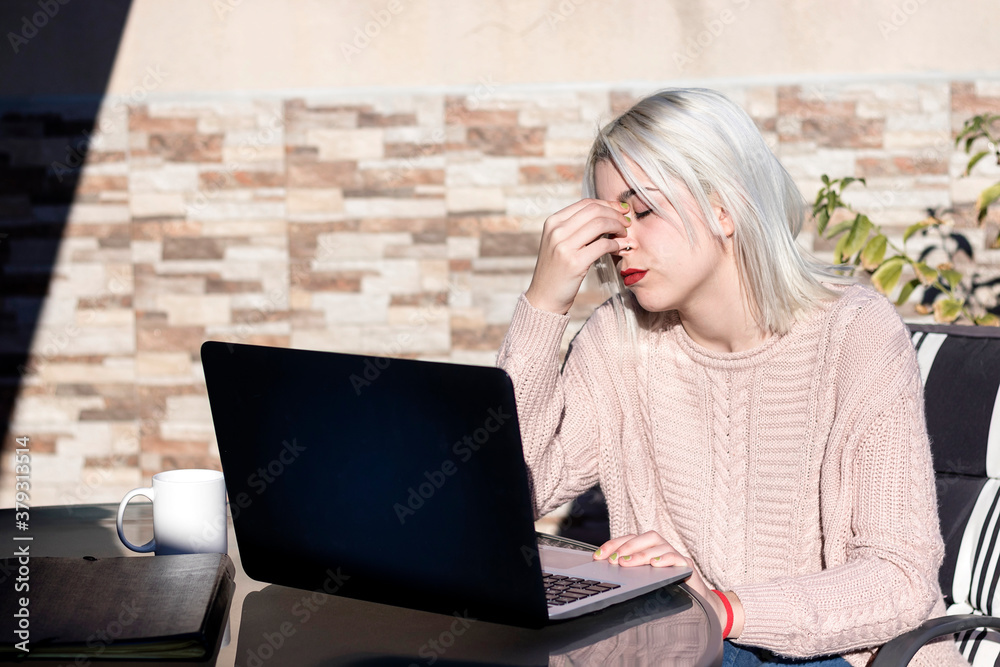 Worried blonde woman working with laptop in a terrace Worried blonde woman working with laptop in a terrace